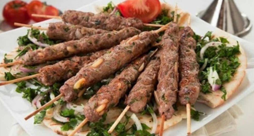 Pinchos morunos servidos con pan y hierbas